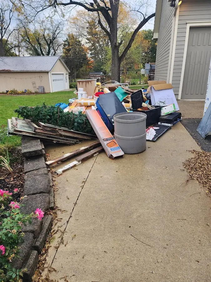 Dumpster being loaded with debris for 12 Yard Dumpster Rental in Grand Ledge